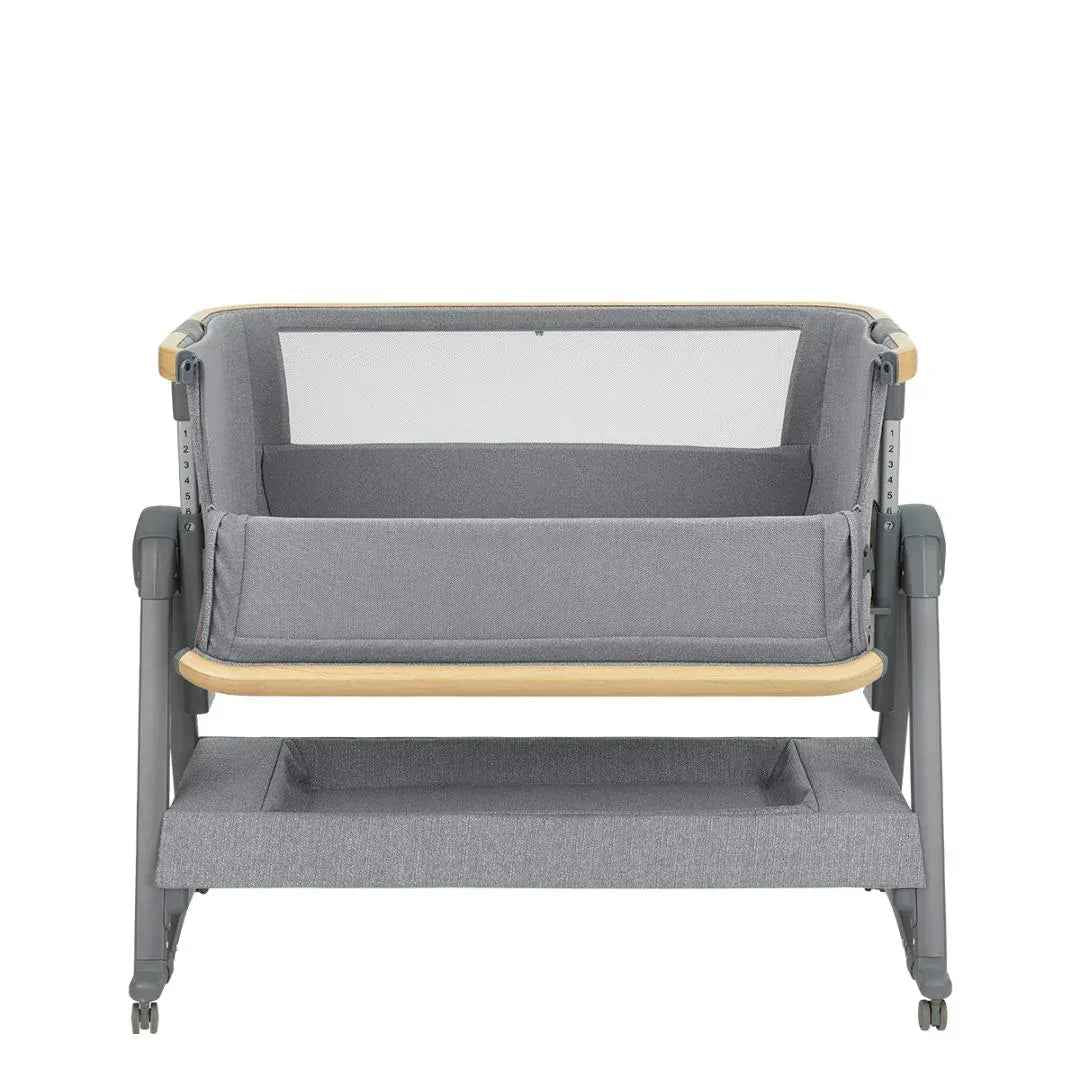 Grey bedside crib with curved bolster front, mesh insert, wooden trim rail, on casters