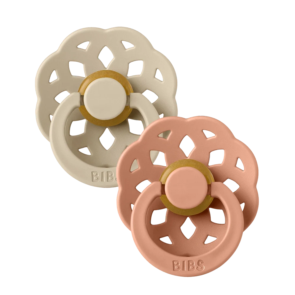 Two latex pacifiers with round vanilla and peach nipples, decorative flower shields