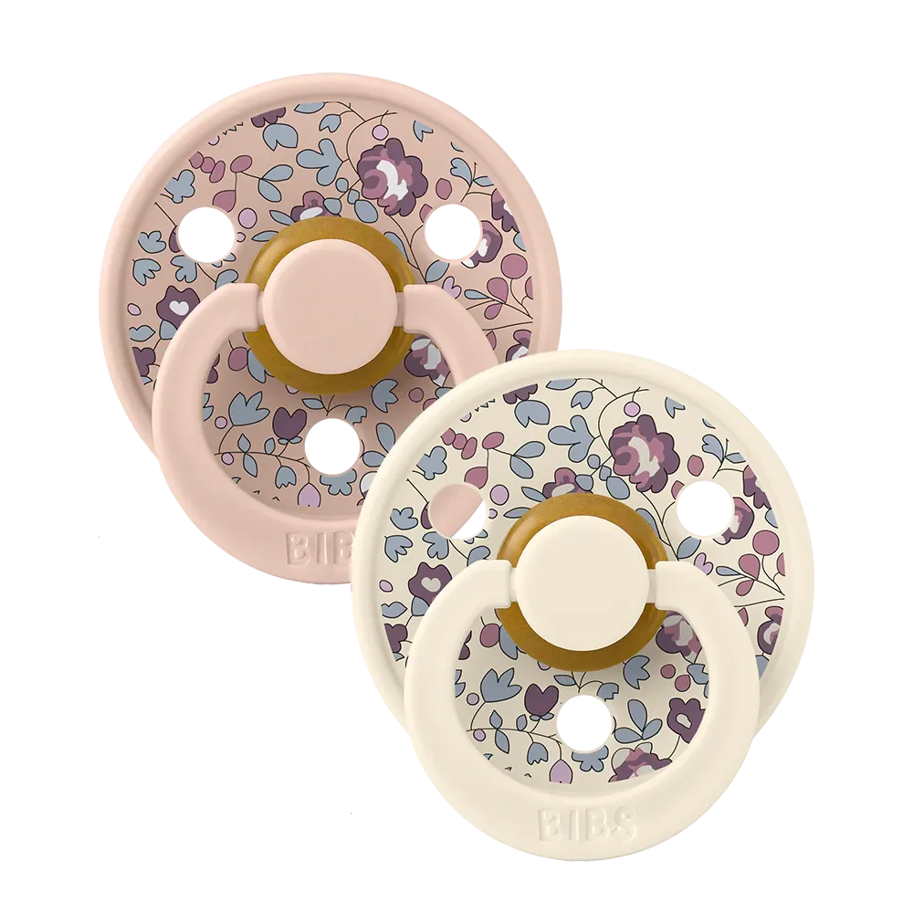 Pair of blush floral latex baby pacifiers with round shields and shield loops