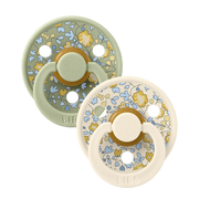Two sage-mixed floral latex baby pacifiers, round shield with yellow ring detail