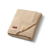 Brown cotton blanket folded, showing flannel lining and stitched border edge