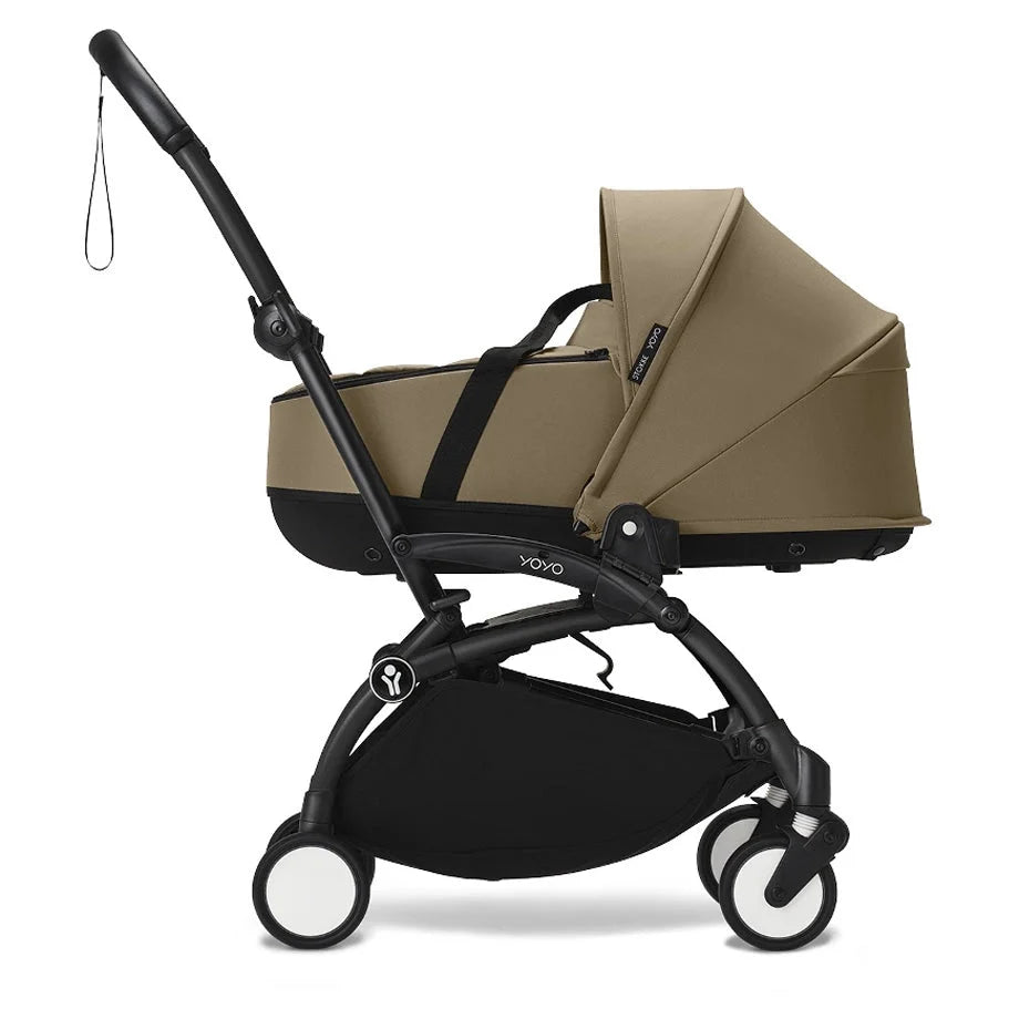 Newborn stroller with toffee tan seat, black wheels, and adjustable canopy