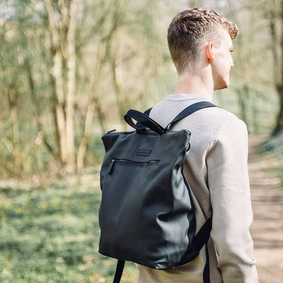 Black changing backpack worn on back with shoulder straps and top handle