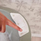 White digital thermometer sensor panel positioned over water, controls visible