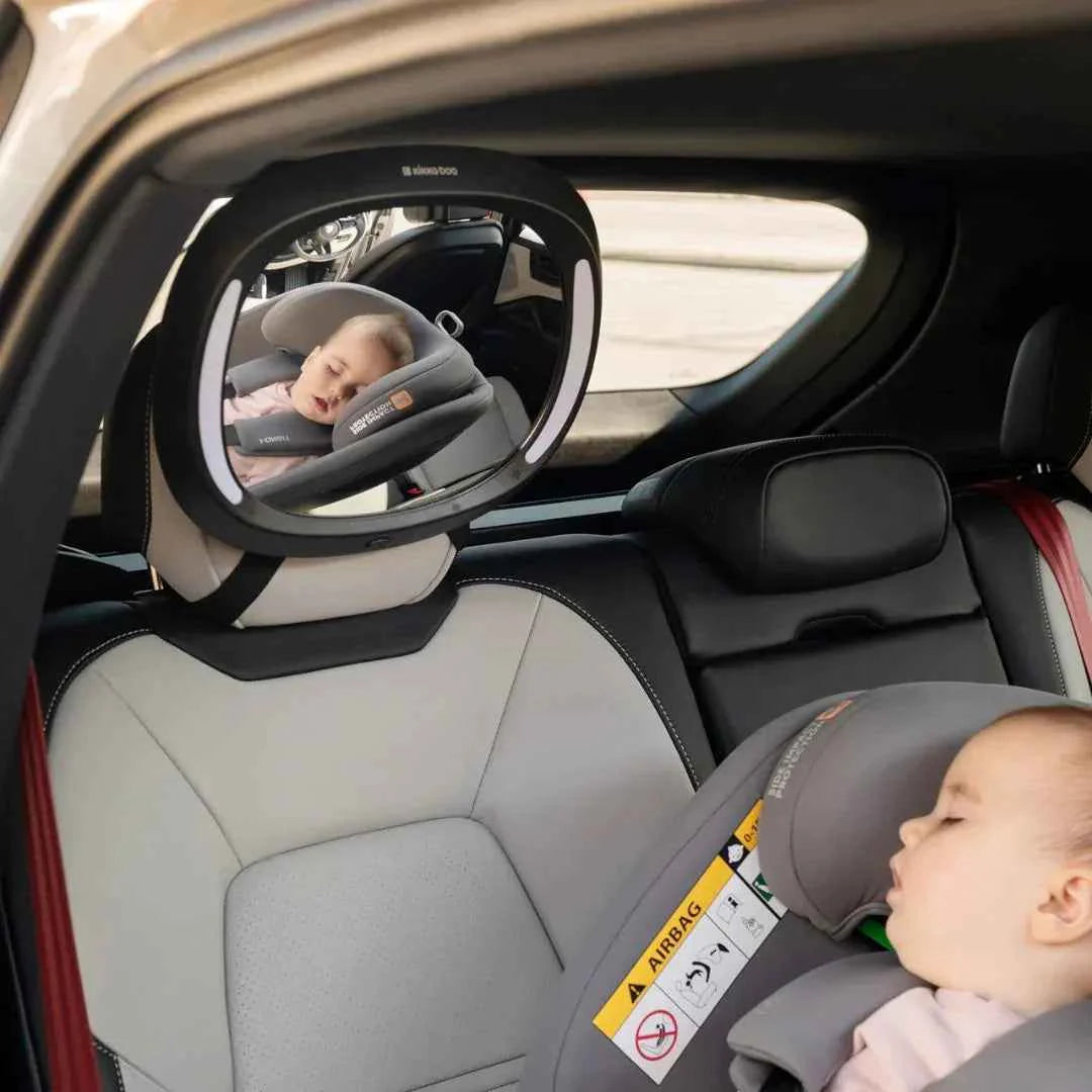 LED rearview car mirror mounted inside car, circular lens showing rear-seat baby