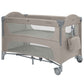 Beige two-level baby cot with mesh side panels and rounded padded headboards