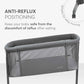 Dark grey bedside crib with padded top rail and breathable mesh side panels
