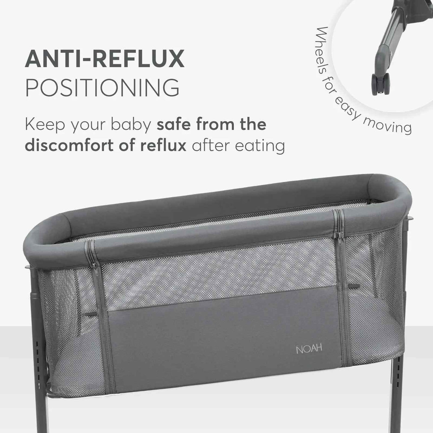 Dark grey bedside crib with padded top rail and breathable mesh side panels