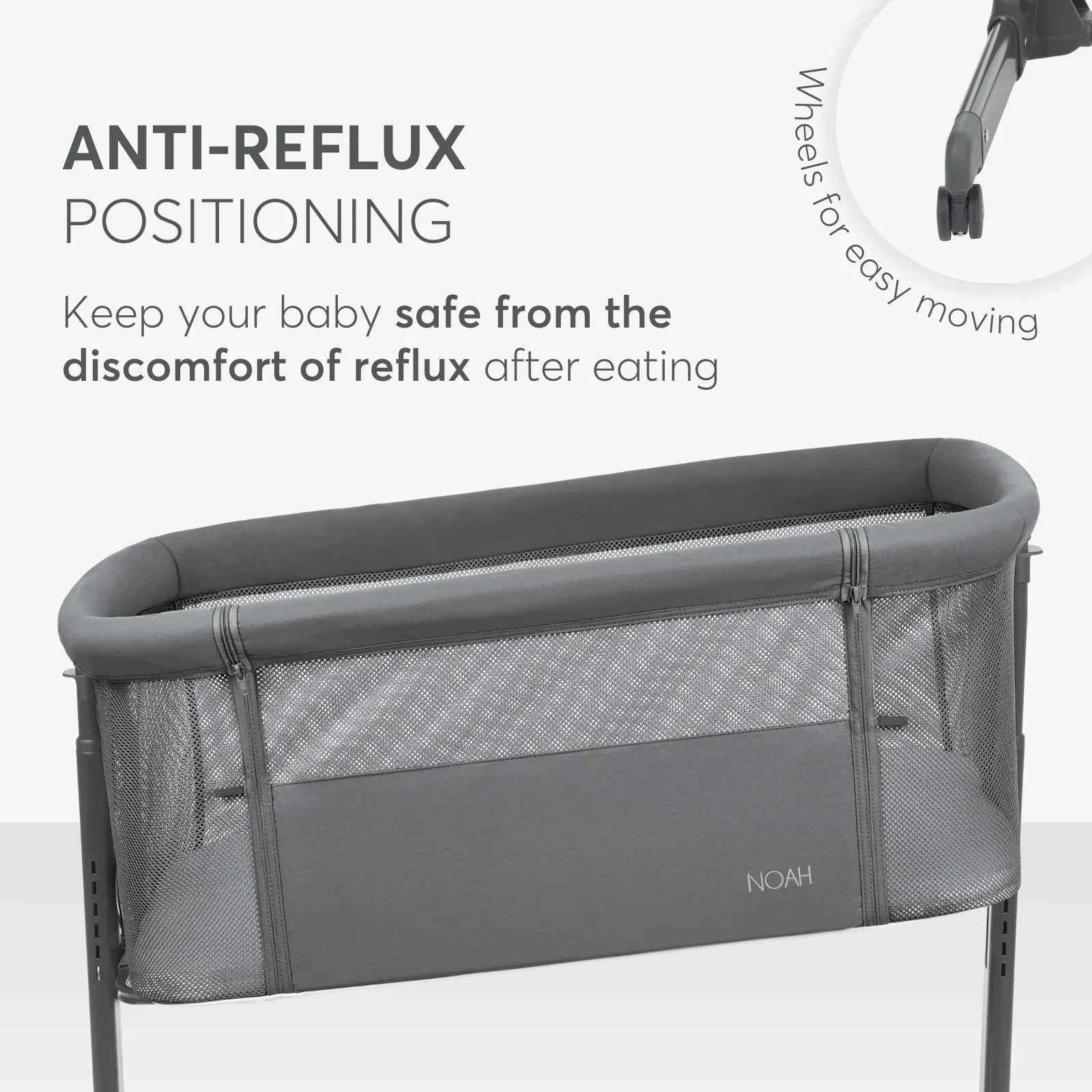 Dark grey bedside crib with padded top rail and breathable mesh side panels