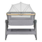 Grey bedside crib with arched fabric canopy and mesh panel, two-level base, caster feet