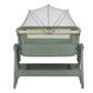 Army green bedside crib viewed from front with white canopy top and mesh curtain sides
