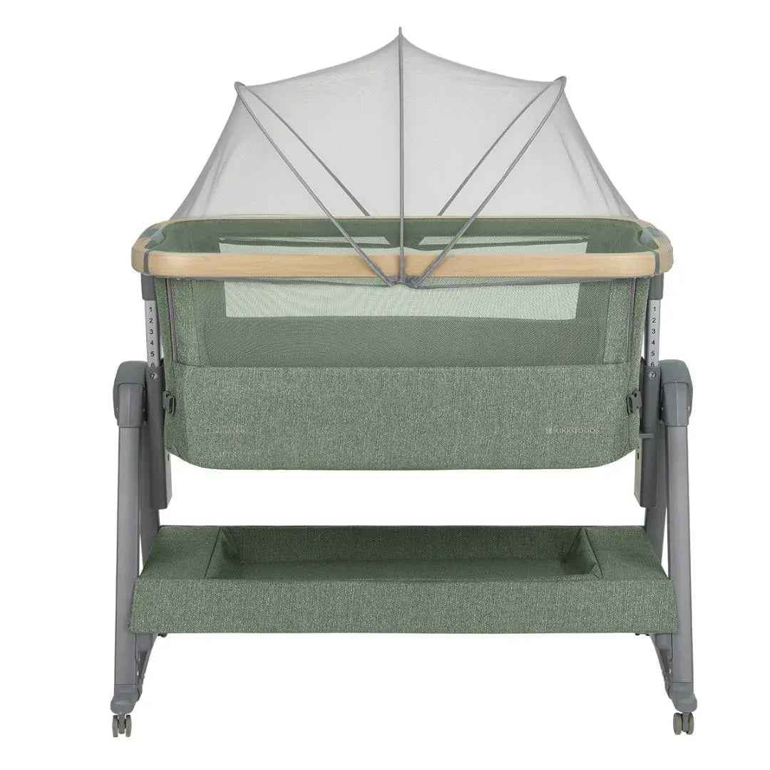 Army green bedside crib viewed from front with white canopy top and mesh curtain sides