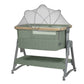 Army green bedside crib with white canopy and mesh sides, wooden rail, and wheels