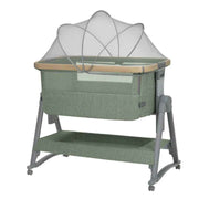 Army green bedside crib with white canopy and mesh sides, wooden rail, and wheels