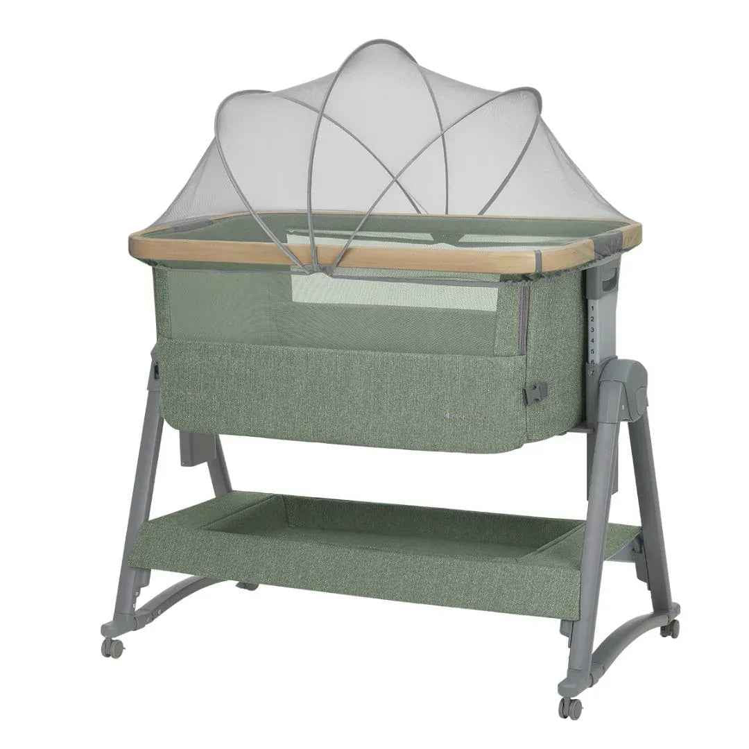 Army green bedside crib with white canopy and mesh sides, wooden rail, and wheels