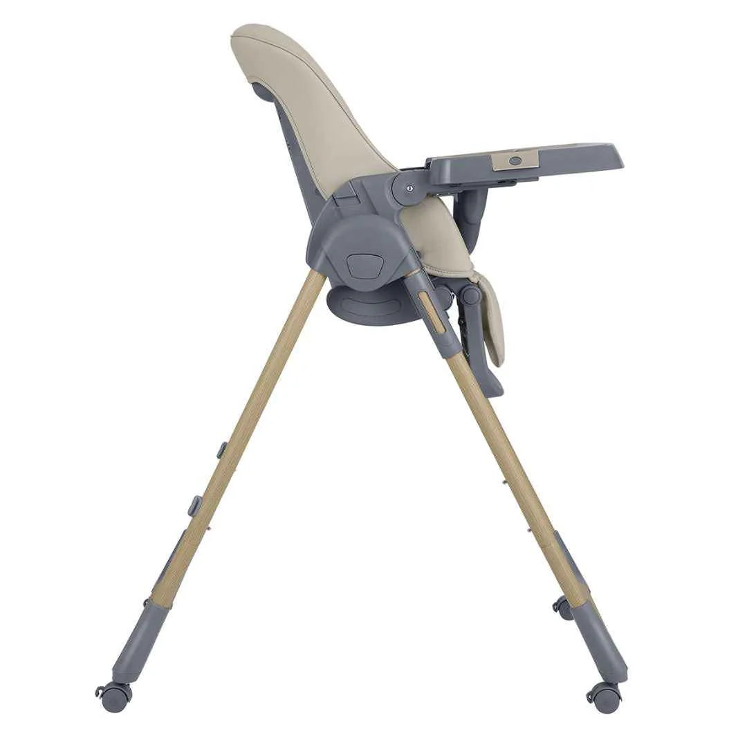 Beige high chair side view with footrest, tray, harness, and caster wheels