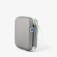 Gray molded grooming kit case with wrist strap, zipper closure, and carry loop