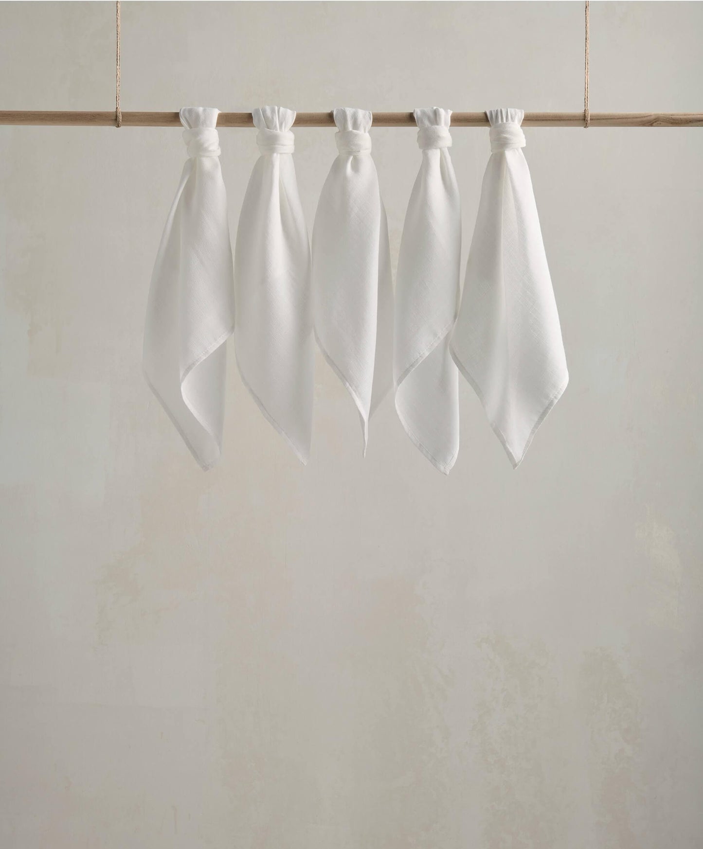 Muslin squares, white cloth squares displayed on a wooden bar with gathered tops