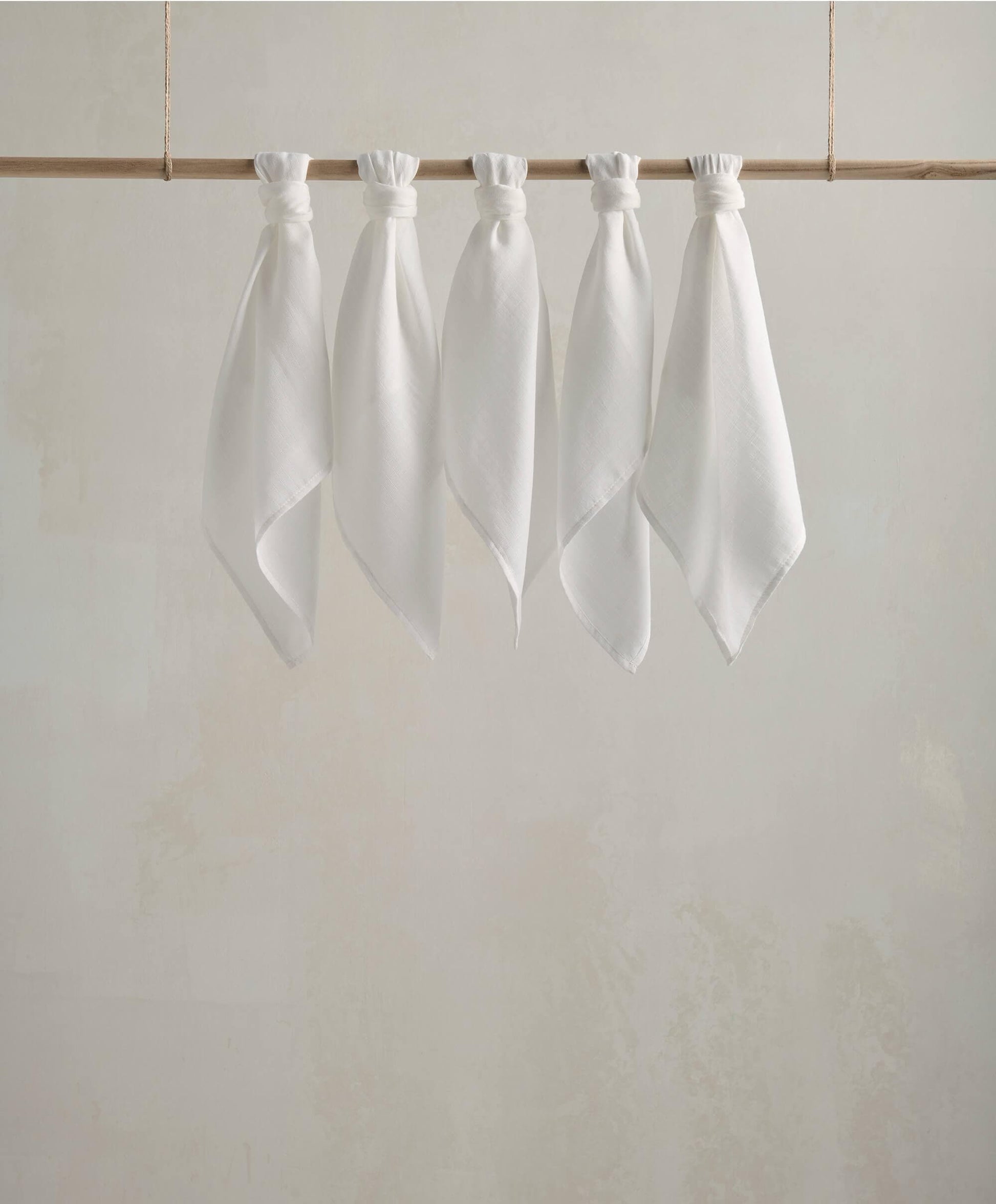 Muslin squares, white cloth squares displayed on a wooden bar with gathered tops