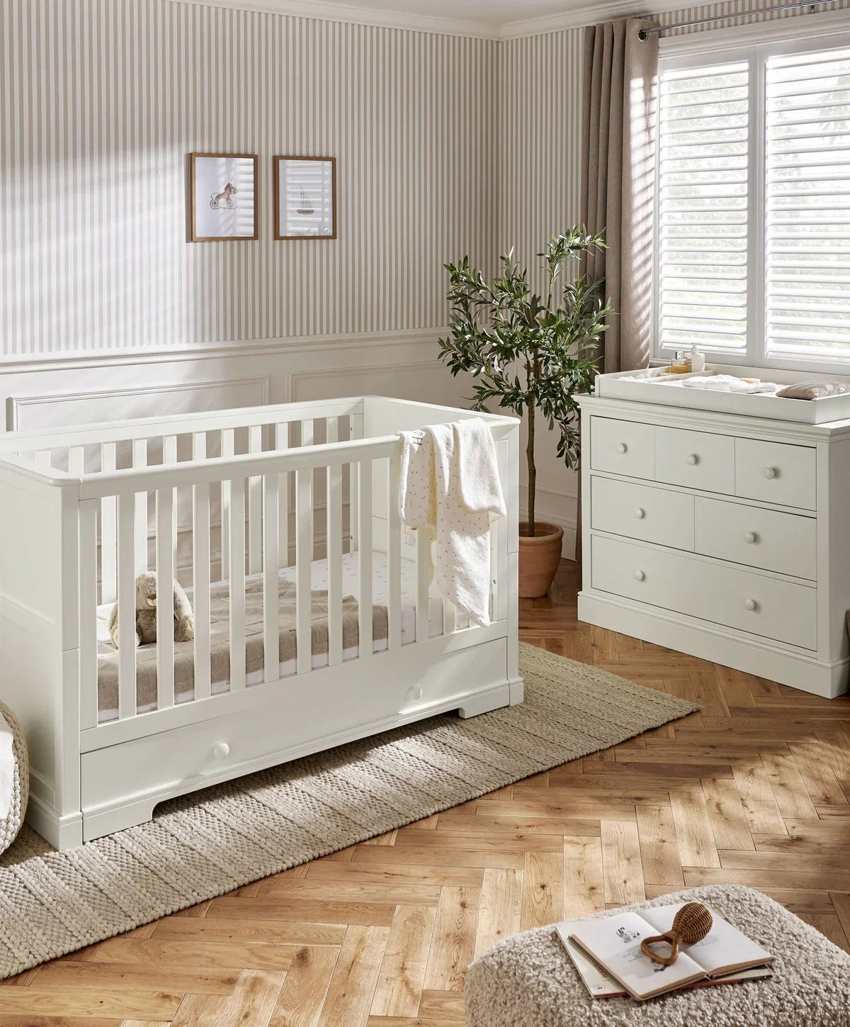 Off-white cot bed with vertical slat rail, viewed from the side
