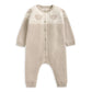 Light beige knitted sleeper romper with long sleeves and allover teddy face yoke