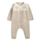 Light beige knitted romper with button placket and teddy bear face stripe