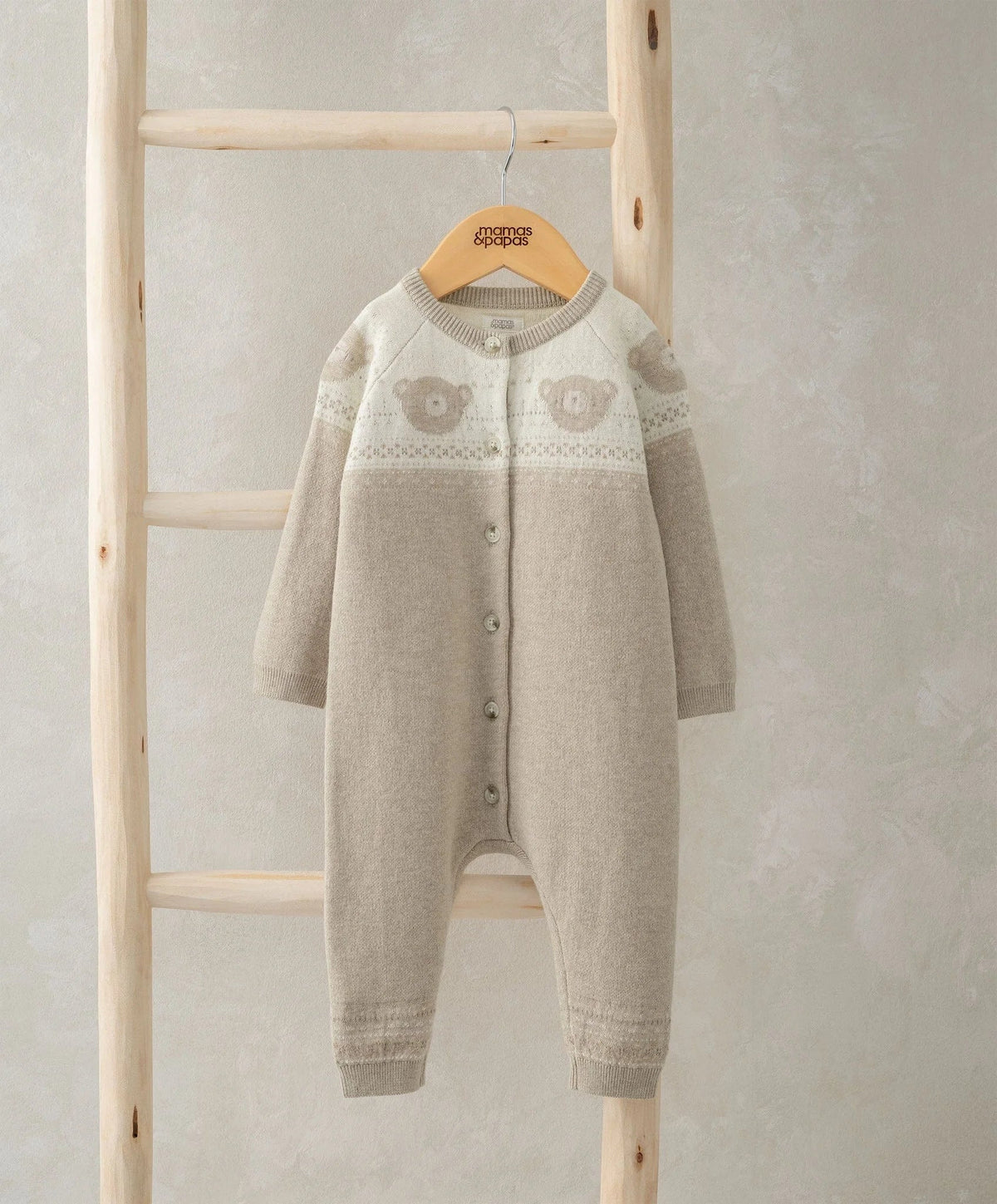 Light beige knitted romper with round neck, long sleeves, button front, teddy knit panel