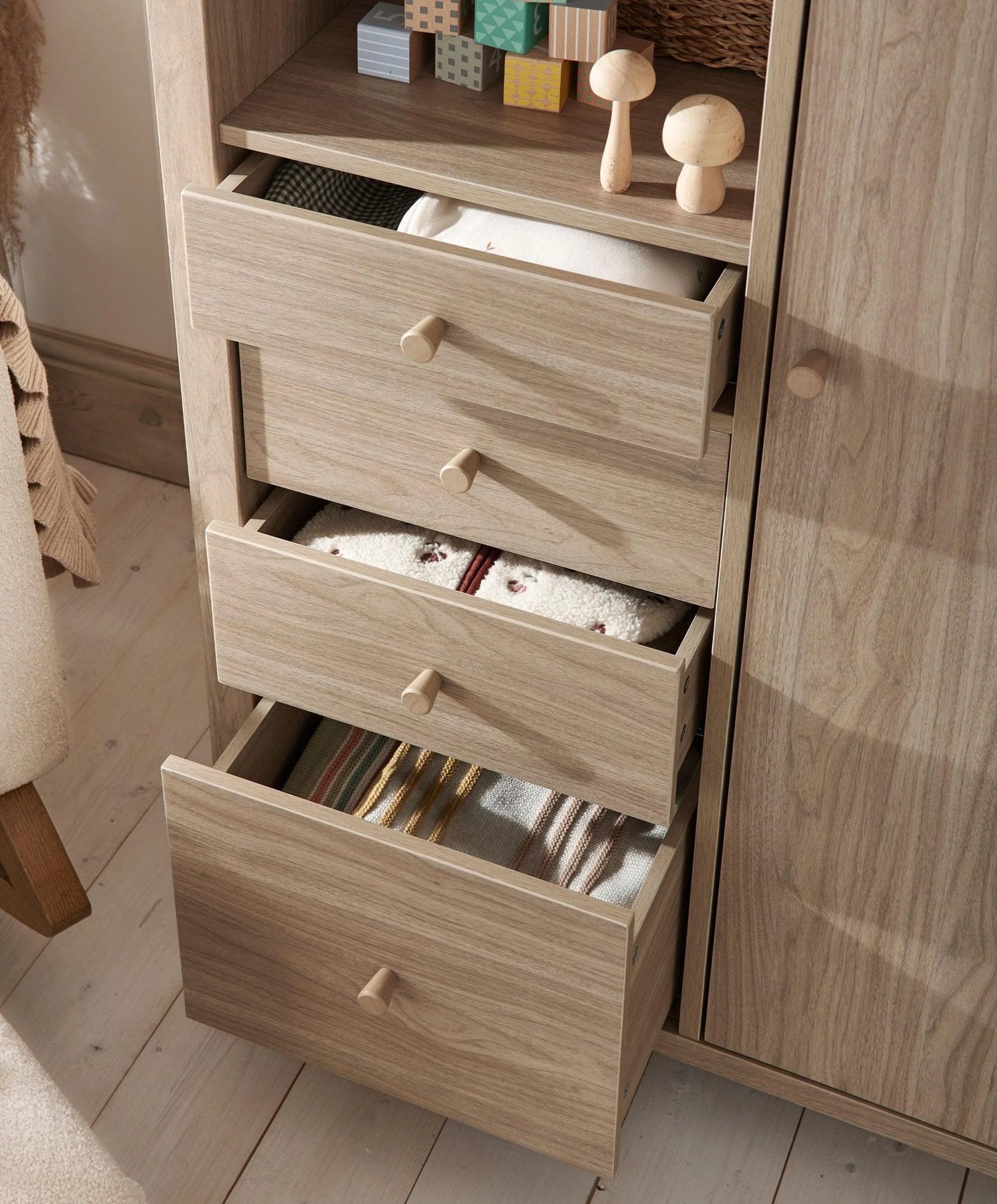 Oak-finish wardrobe with three pull-out drawers and round wooden knobs