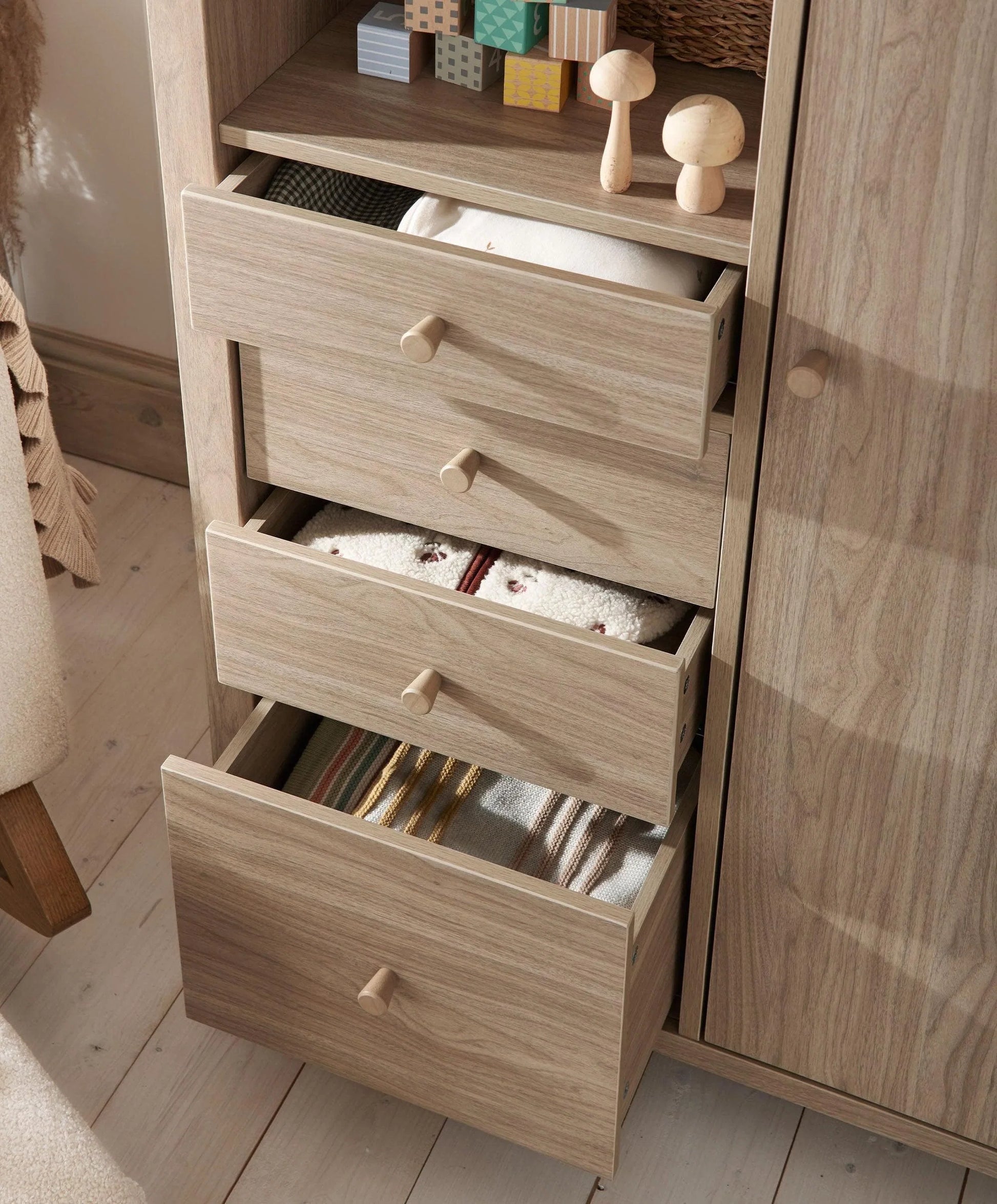 Oak-finish wardrobe with three pull-out drawers and round wooden knobs
