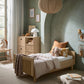 Oak cotbed with arch headboard, styled bedding with quilt and pillows