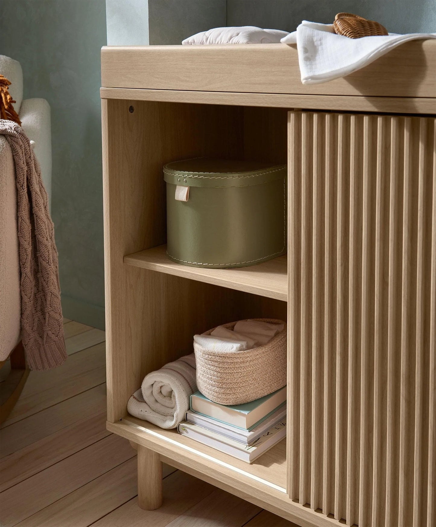 Oak wide dresser changer with open shelf showing baskets and stacked folded linens