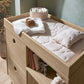 Oak changing dresser with raised top, open shelf, and ribbed storage bins