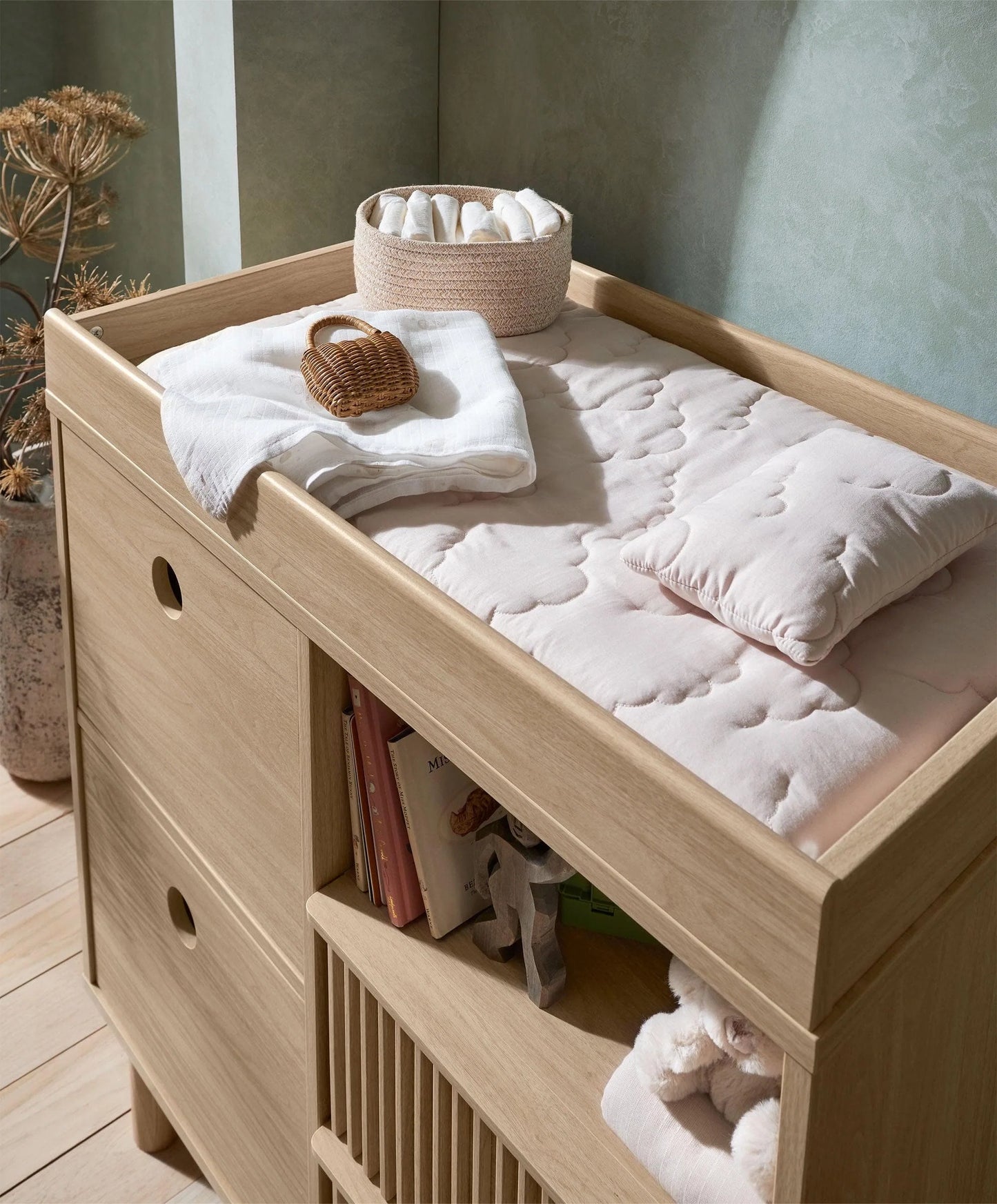 Oak changing dresser with raised top, open shelf, and ribbed storage bins