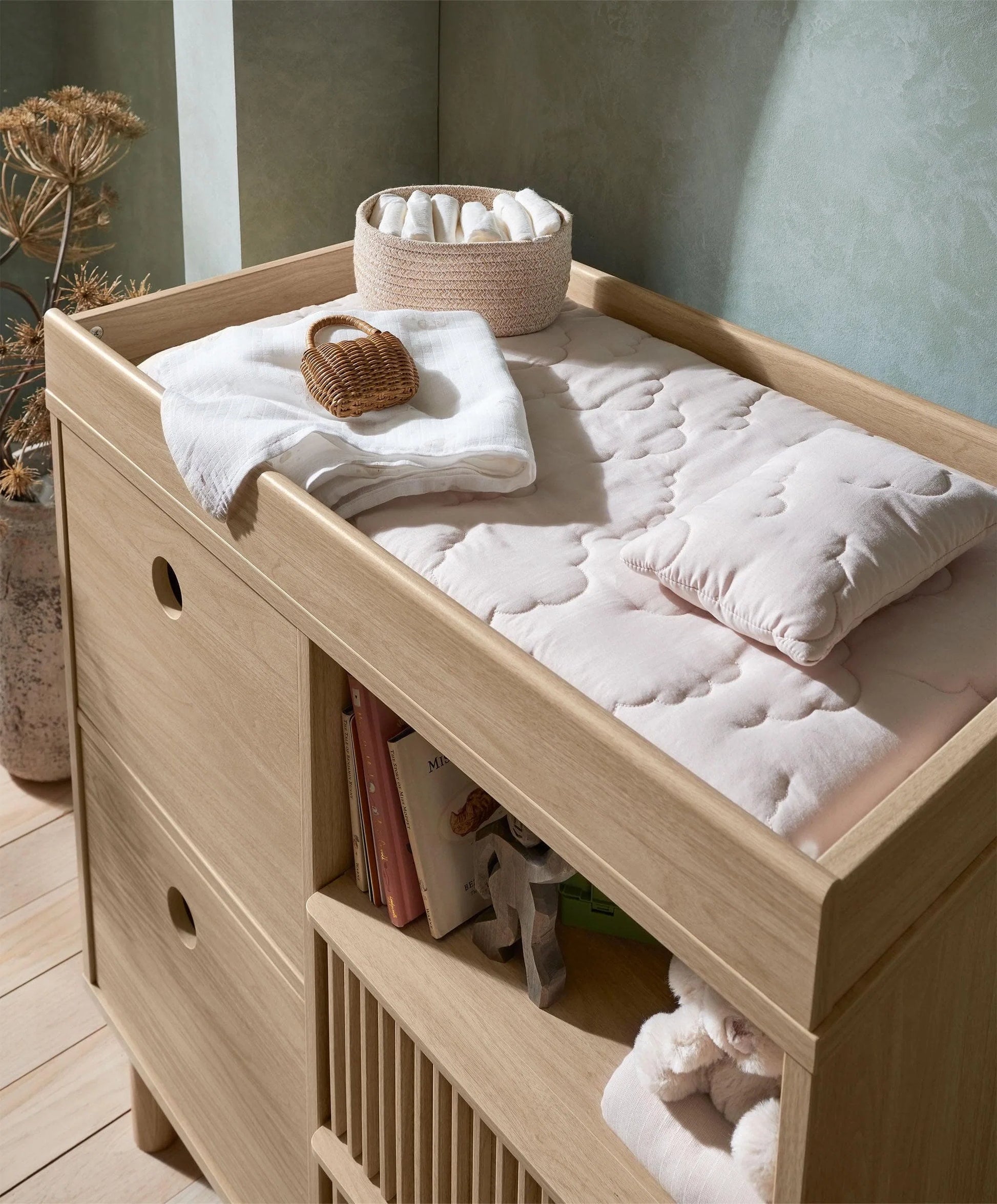 Oak changing dresser with raised top, open shelf, and ribbed storage bins