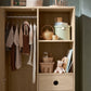 Oak wardrobe with open doors, hanging rail, cubbies, and three drawer fronts