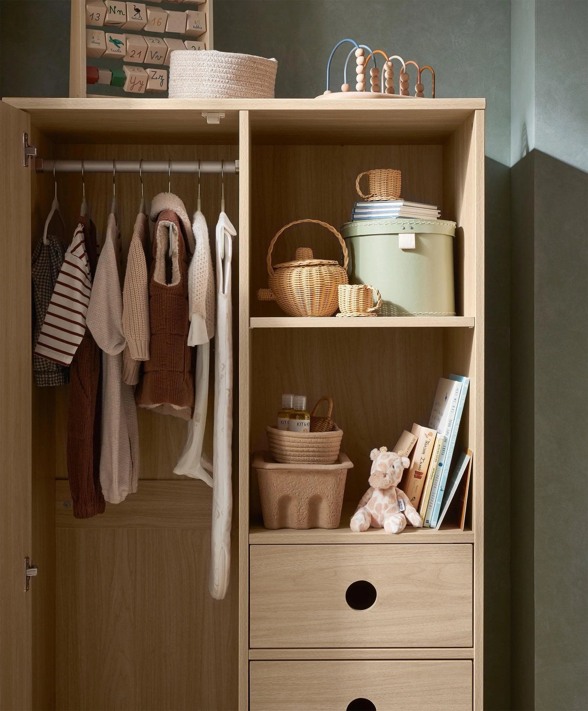 Oak wardrobe with open doors, hanging rail, cubbies, and three drawer fronts
