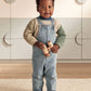 Knitted colour block jumper worn with denim overalls, blue collar and green sleeves
