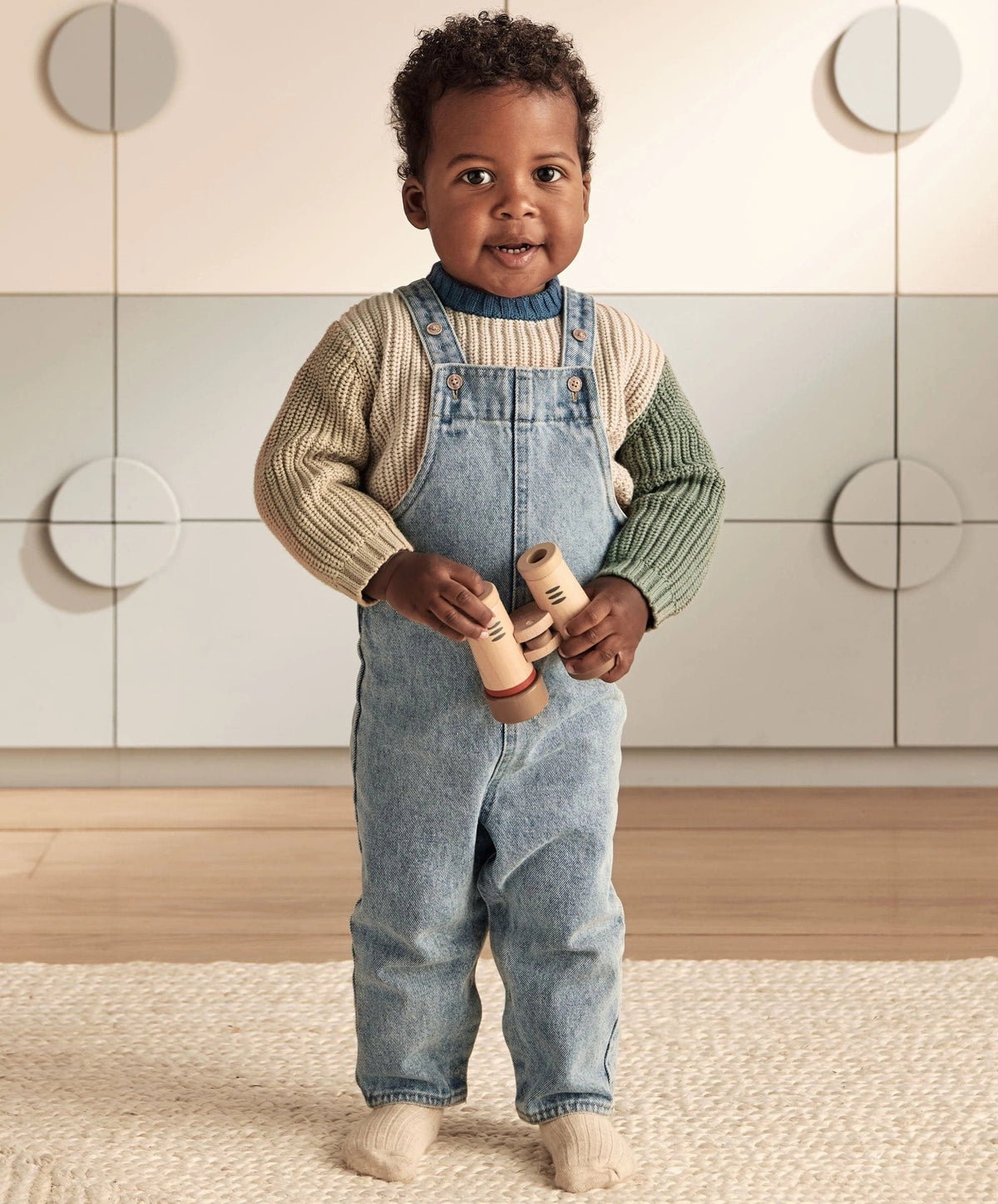Knitted colour block jumper worn with denim overalls, blue collar and green sleeves