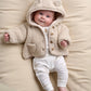 Cream hooded borg jacket with snap front, two chest pockets, teddy texture.