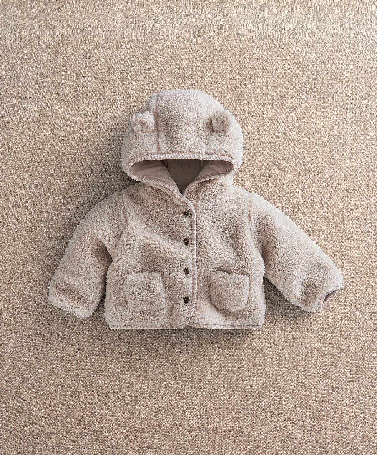 Cream hooded borg jacket with button front and two flap pockets.