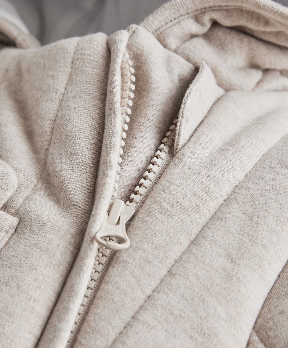 Light gray jersey pramsuit front zip detail with textured stitching and pull