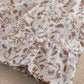 Floral dress fabric detail with gathered ruffles and small botanical print