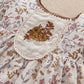 Floral dress bodice close-up with embroidered bib, lace trim and puff sleeves