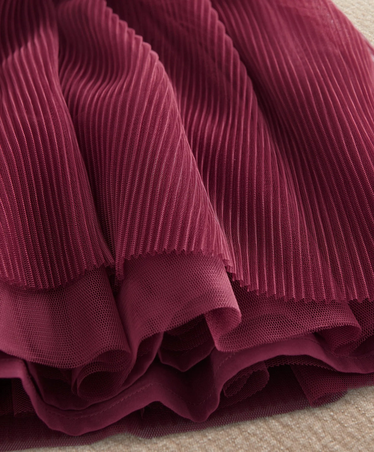 Burgundy pleated skirt hem with layered ruffle tiers