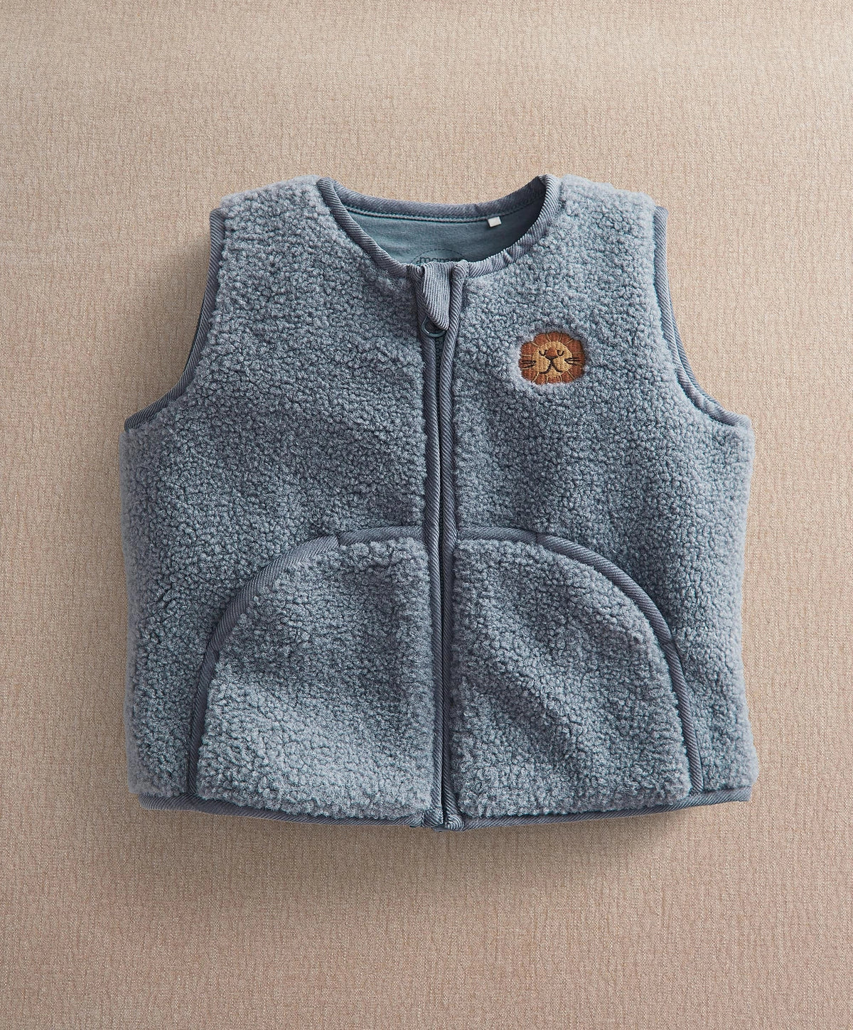 Blue fleece sleeveless gilet with zip front and lion badge