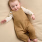 Baby dungaree and bodysuit set on infant: tan ribbed overalls with front pockets