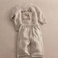Cream knitted baby set with long-sleeve snail applique top and speckled pants