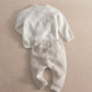 Cream knit 2-piece baby set, long-sleeve top and pants with ribbed cuffs and hem (back).
