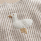 Cream knit sweater with duck applique on chest, ribbed texture, long sleeves