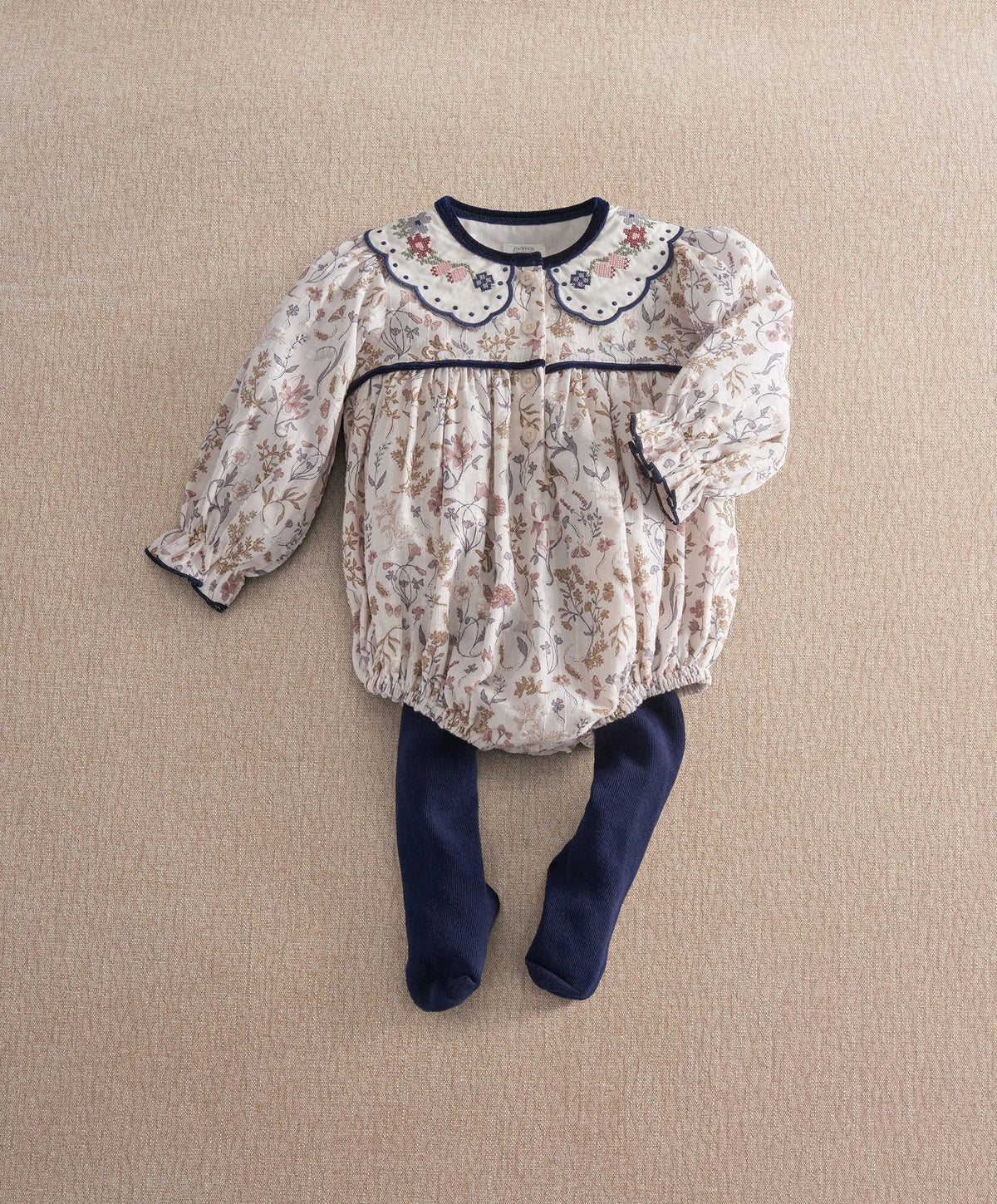 Floral romper with long sleeves, scalloped navy collar, and navy tights